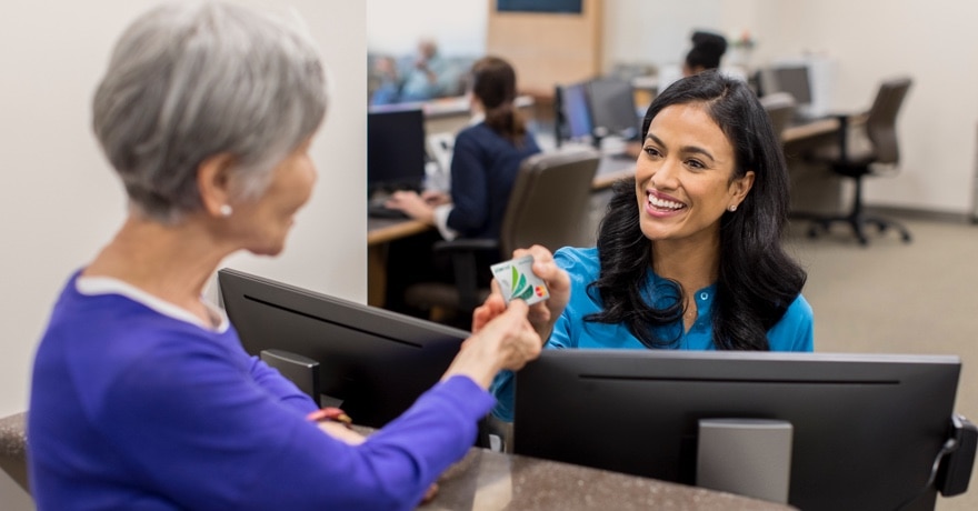 Woman handing a credit card to a receptionist
