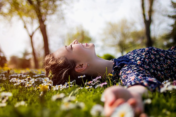 Woman smiling as she lays on grass and flowers