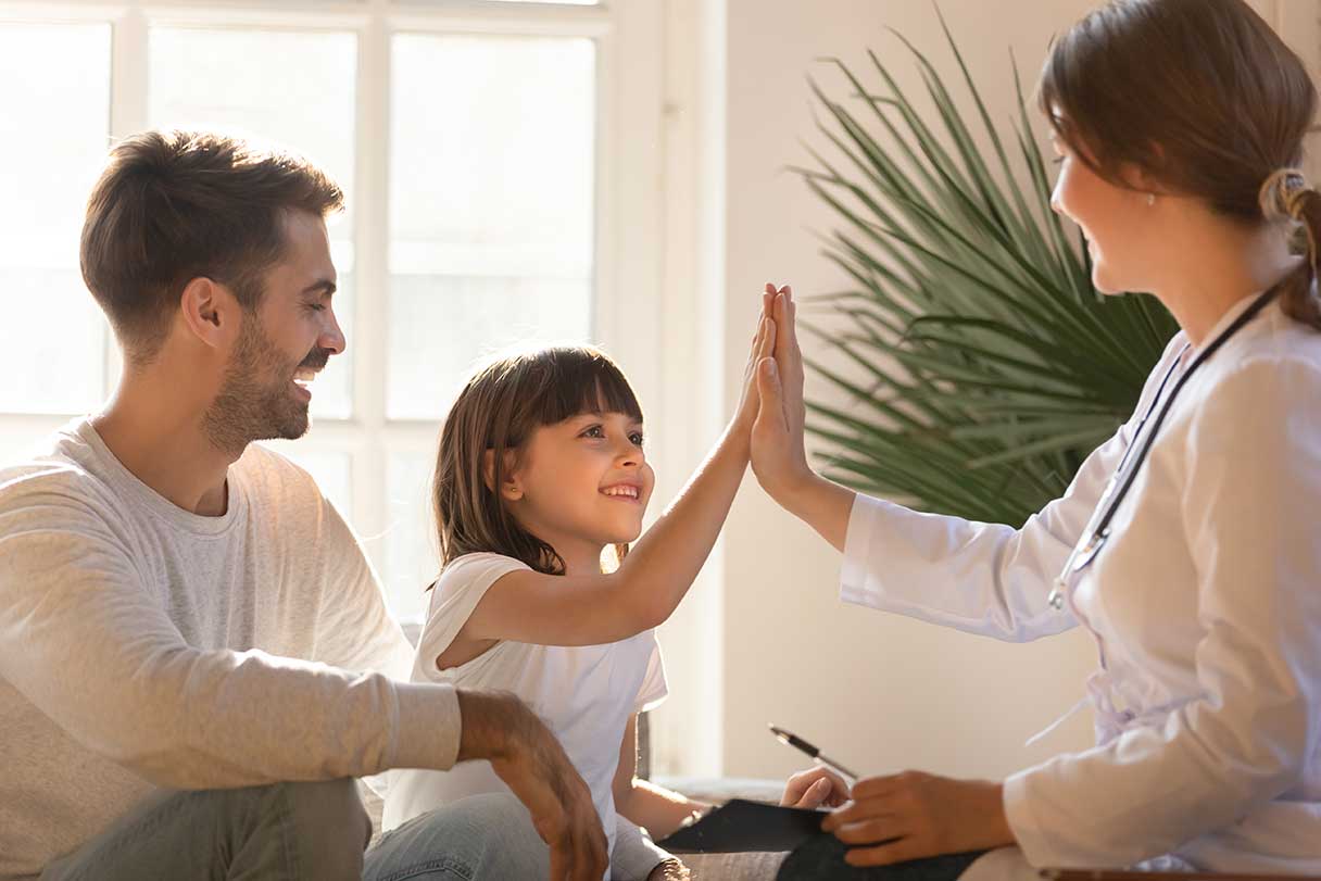 Family of three, mother high-fiving small child