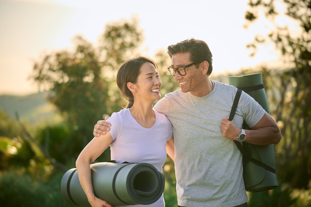 Couple walking outside with yoga mats