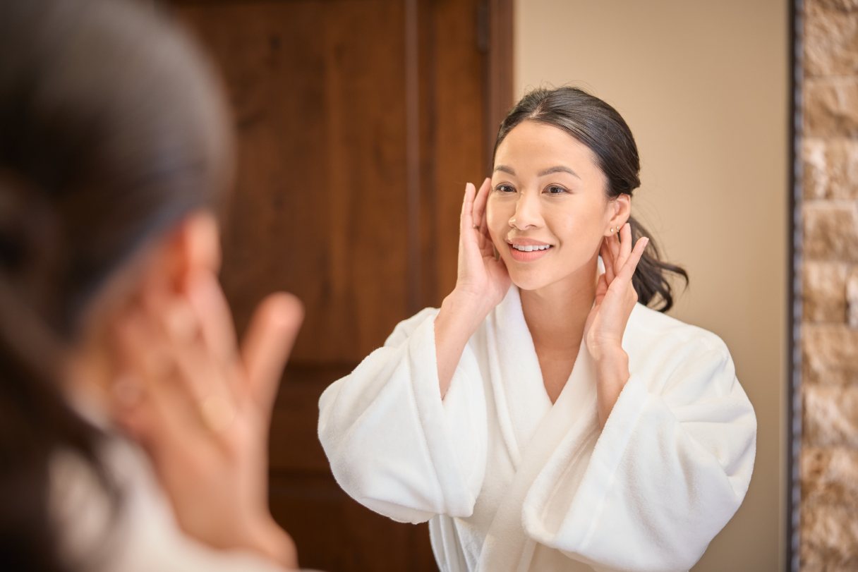 Woman looking at her face in a mirror