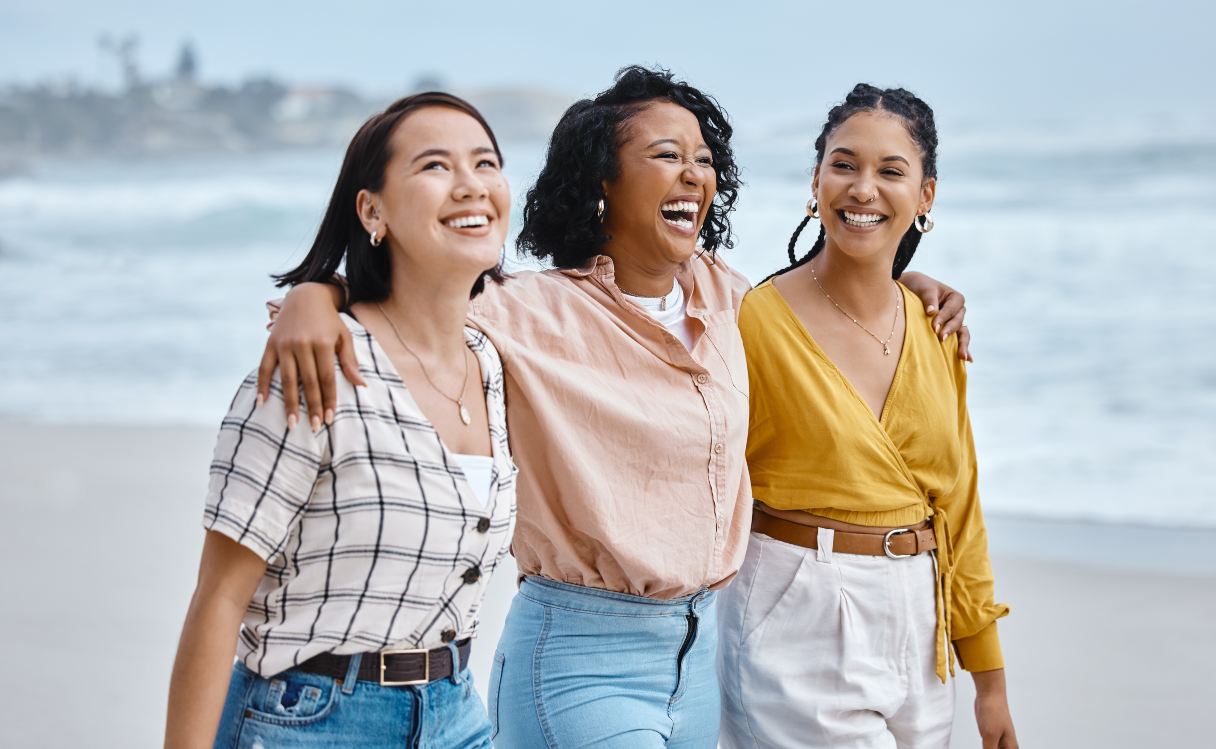 Three women walking on a beach together