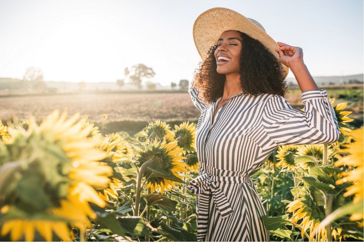 Woman smiling in field of sunflowers