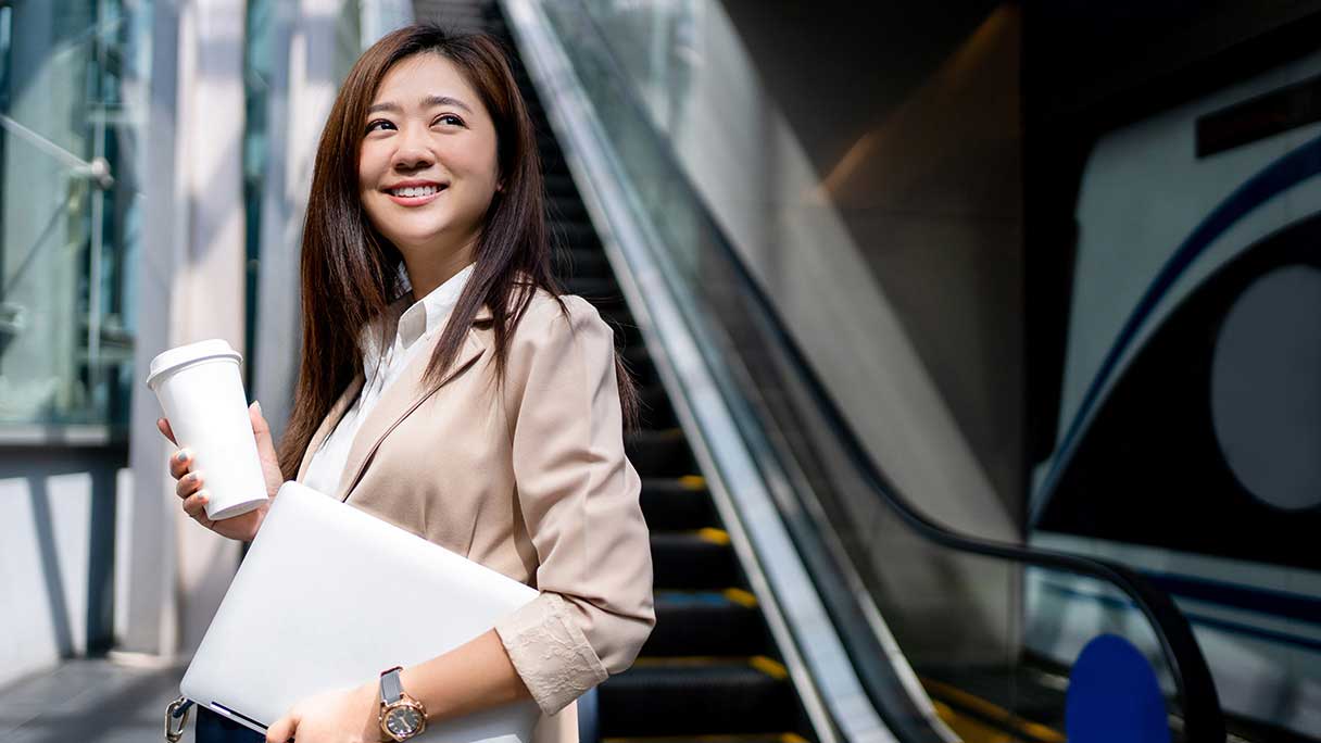 Smiling woman standing next to escalator