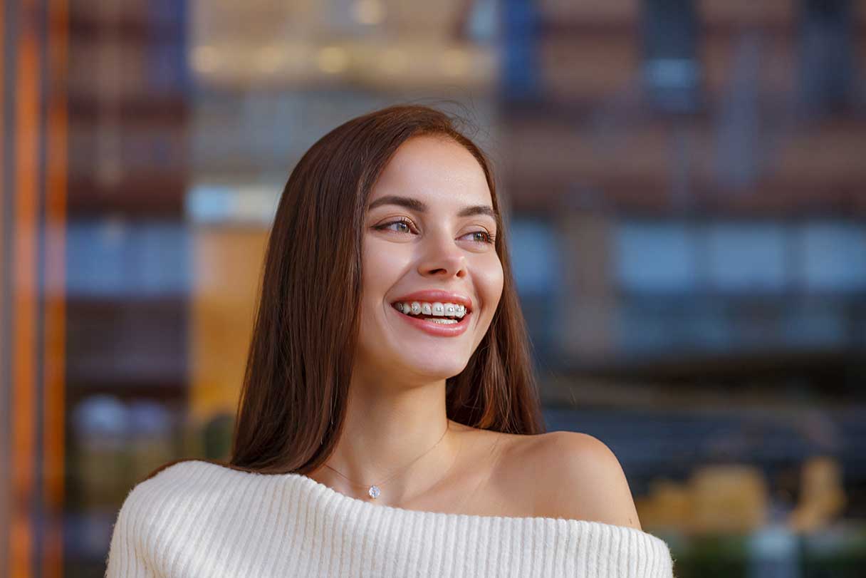 Smiling young woman with braces on her teeth