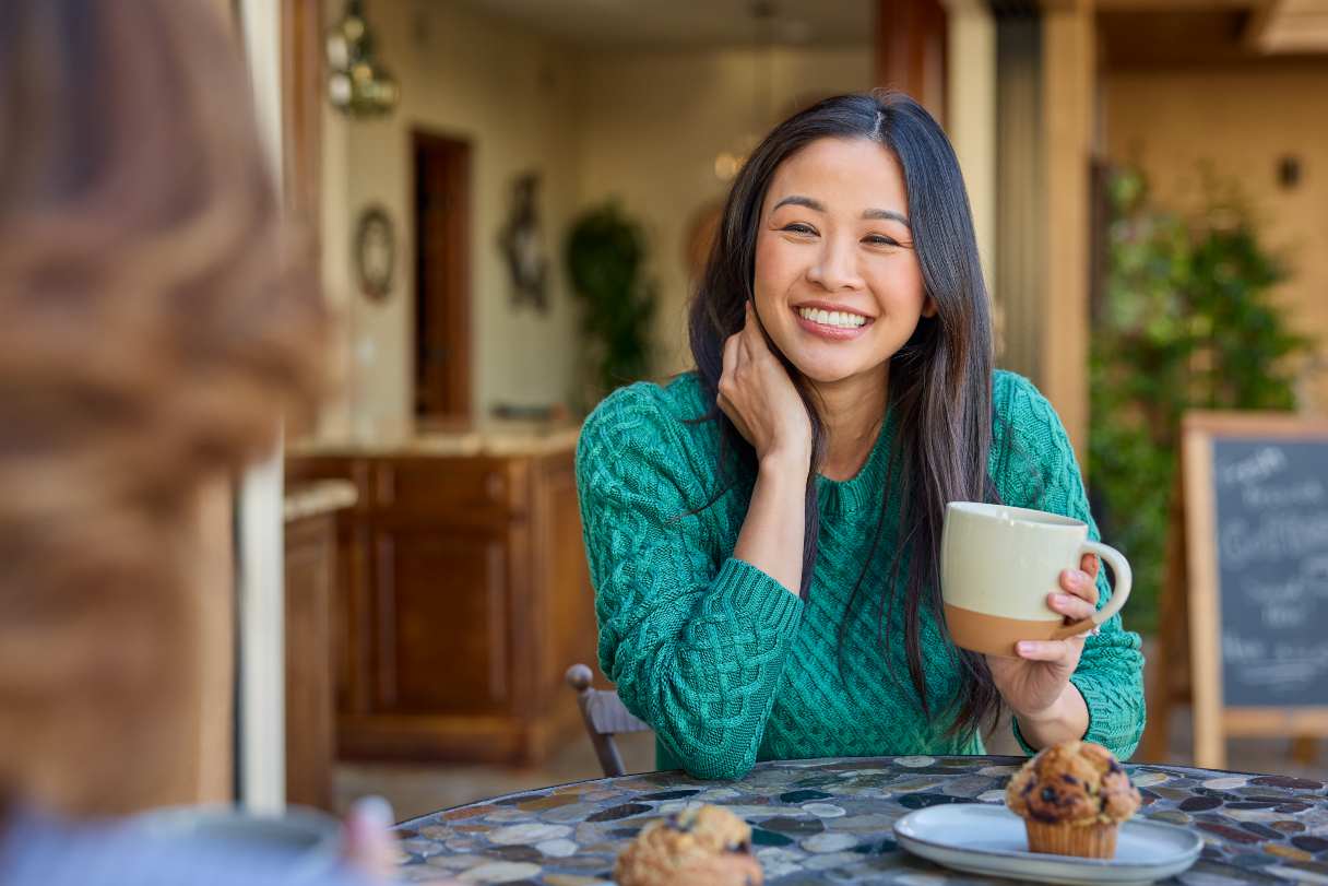Woman holding coffee mug, smiling