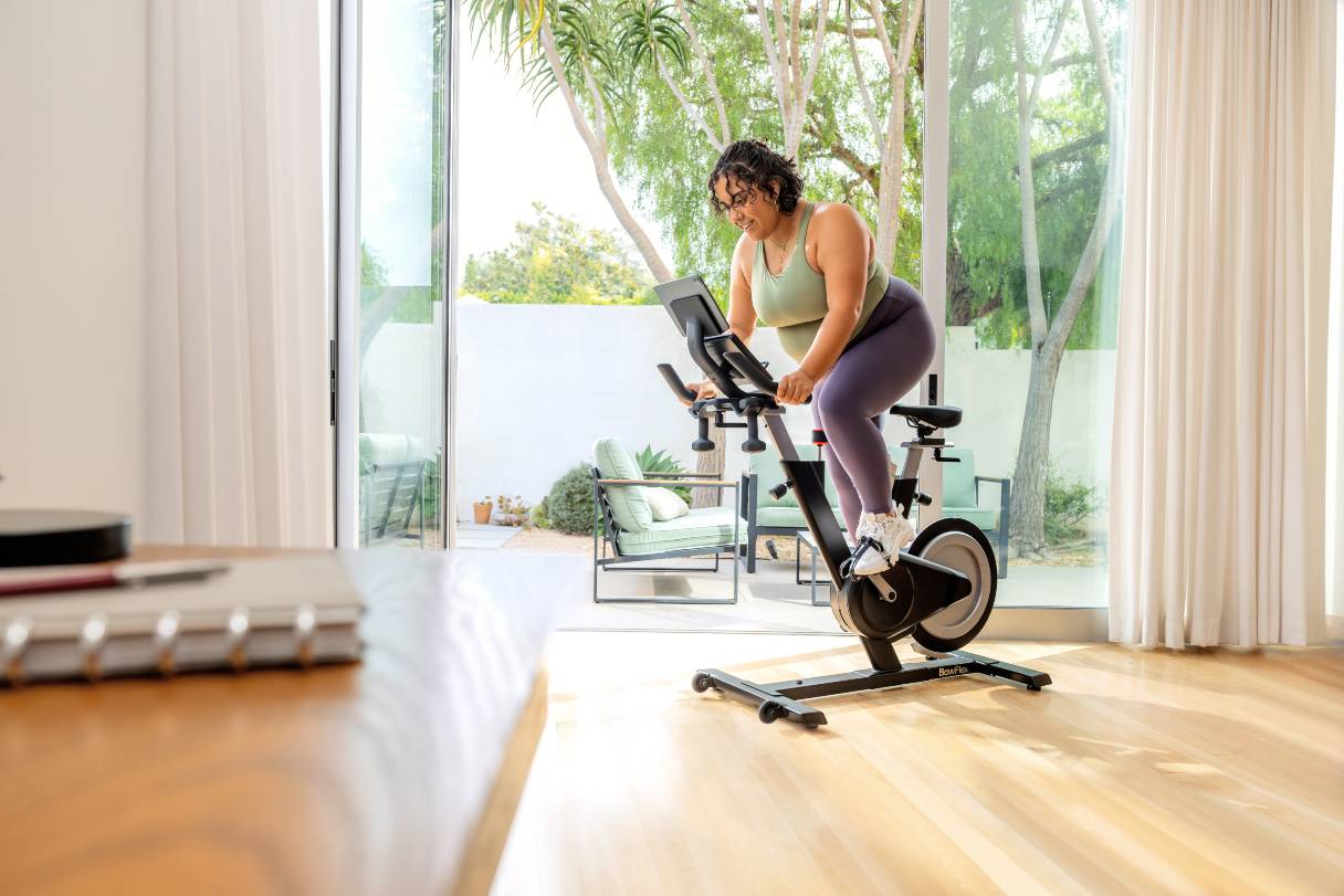 Woman riding a spin bike in her home