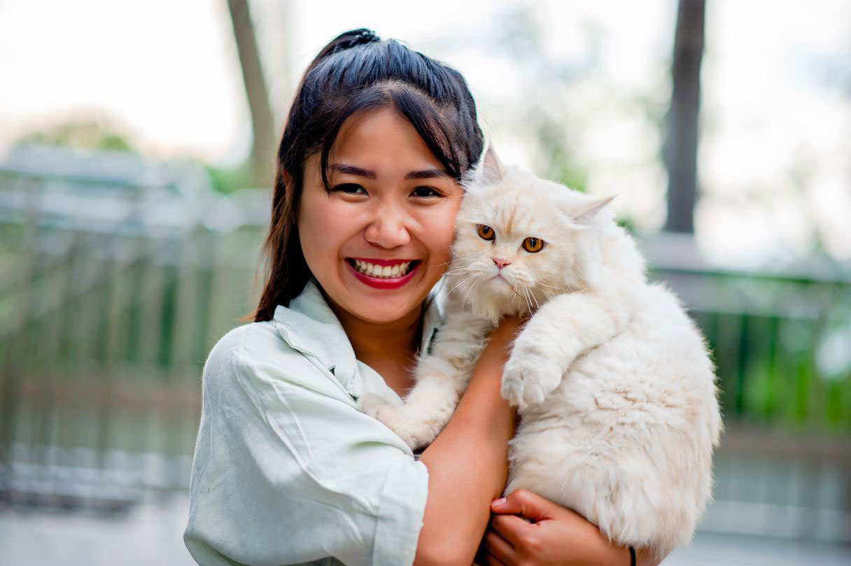Woman holding a cat to her cheek