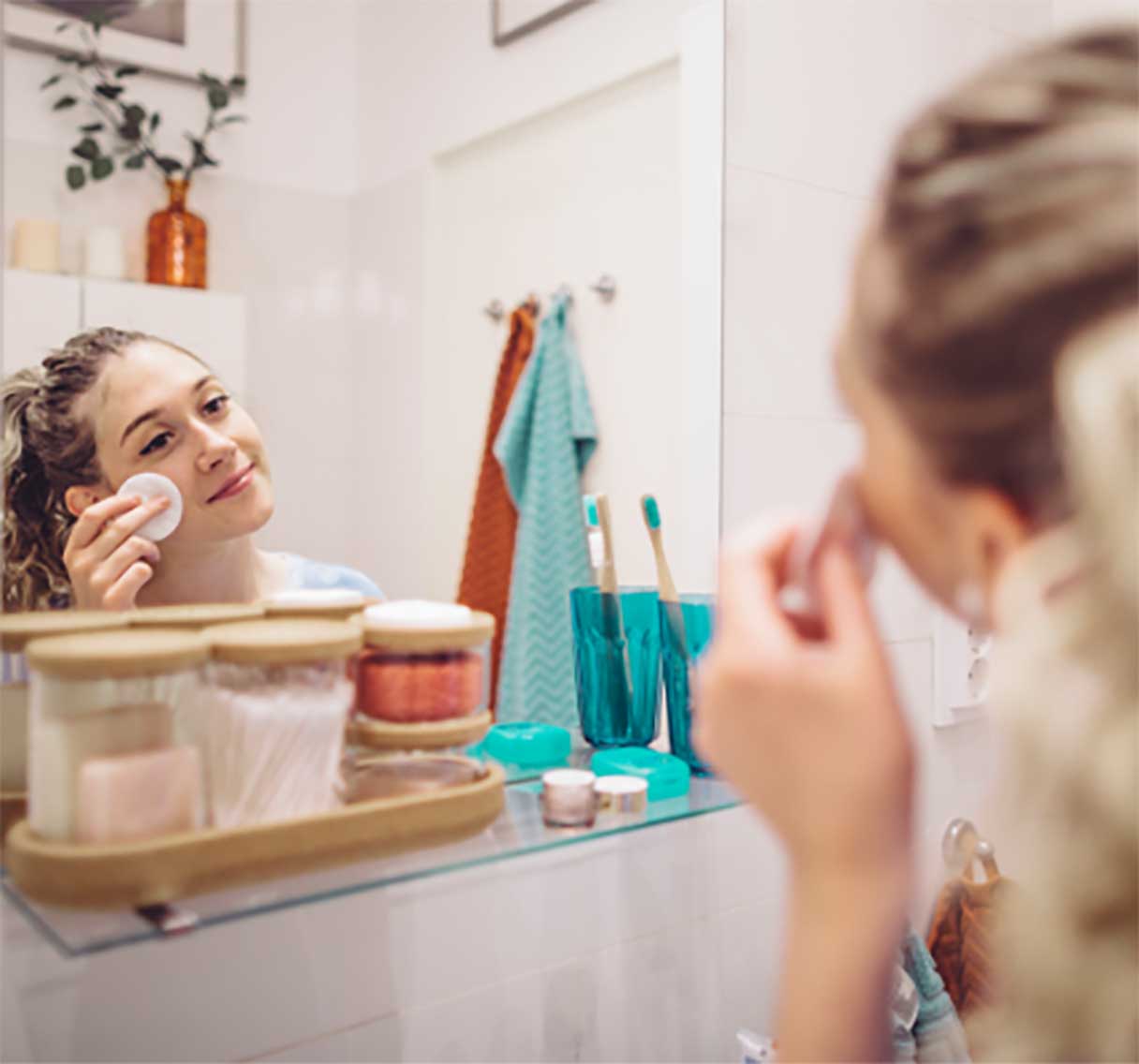 Woman rubbing cotton round against her cheek