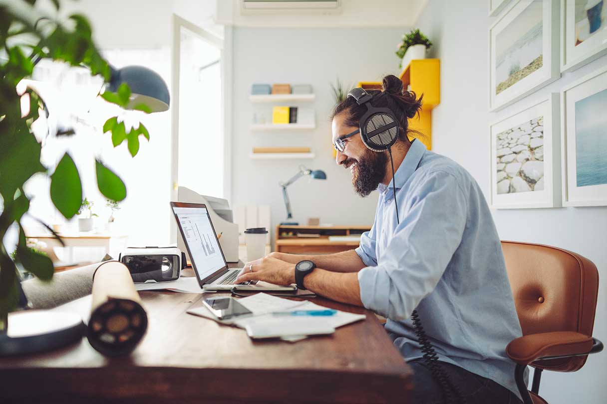 Man wearing headphone, working on laptop