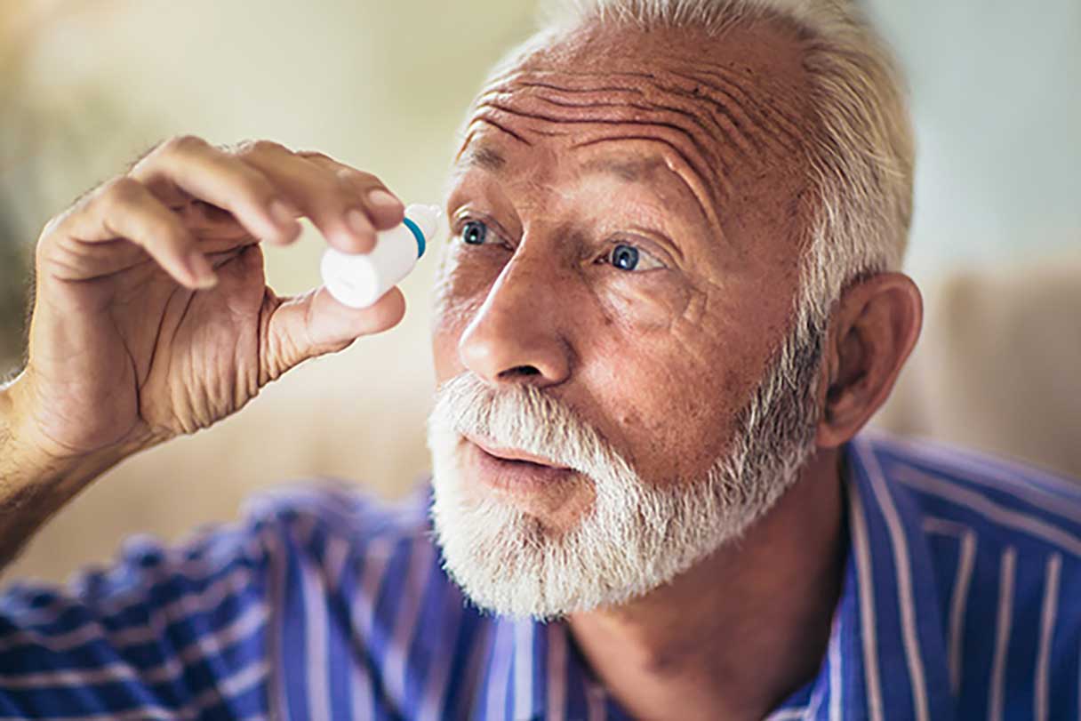 Man applying eye drops to eye