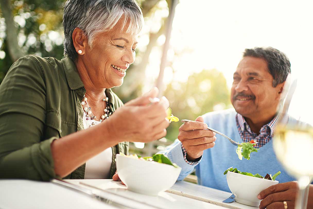 Smiling couple eating meal outside