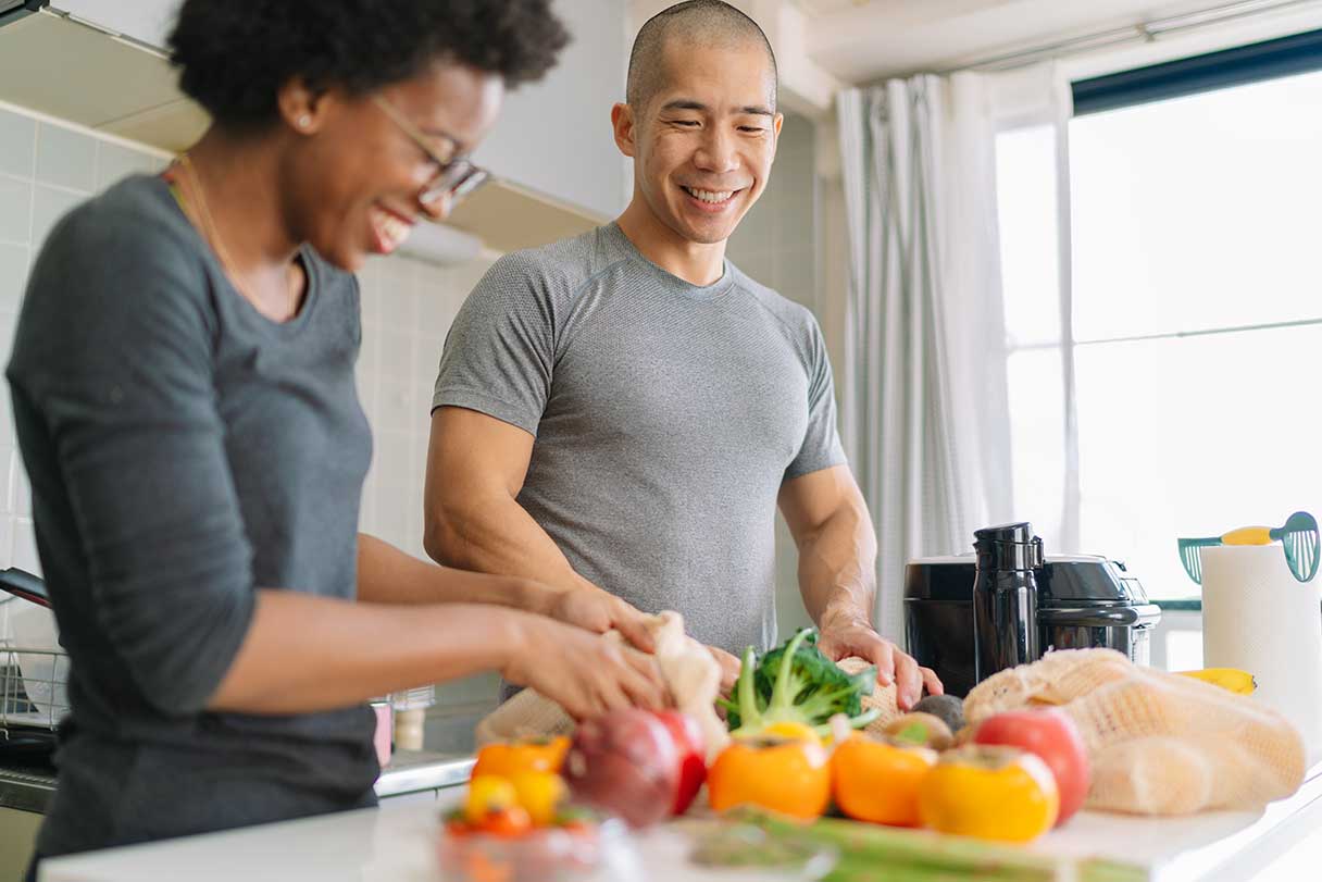 Man and woman chopping vegetables in a kitchen