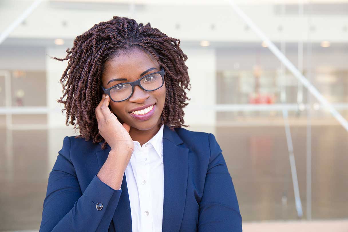 Woman wearing business casual attire and glasses, speaking on cell phone
