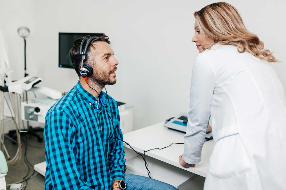Woman conducting hearing test on male patient
