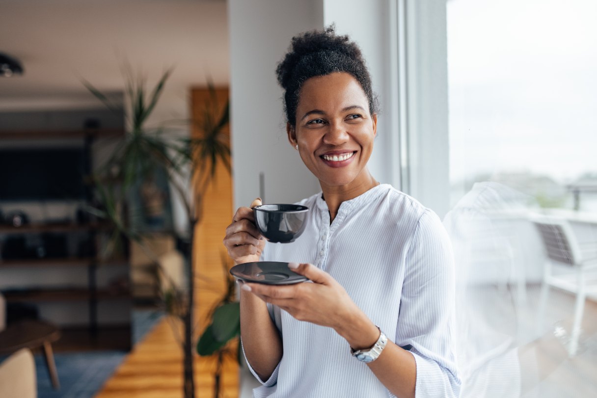 Woman smiling and drinking coffee