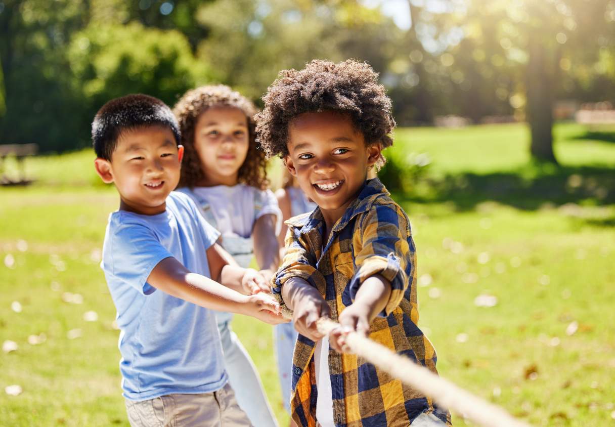 Three children playing tug-of-war
