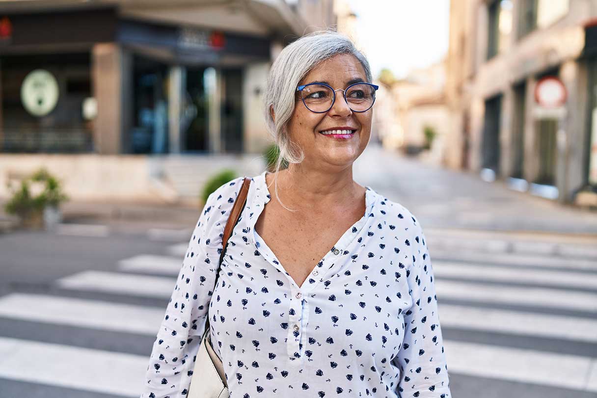 Smiling woman walking on crosswalk