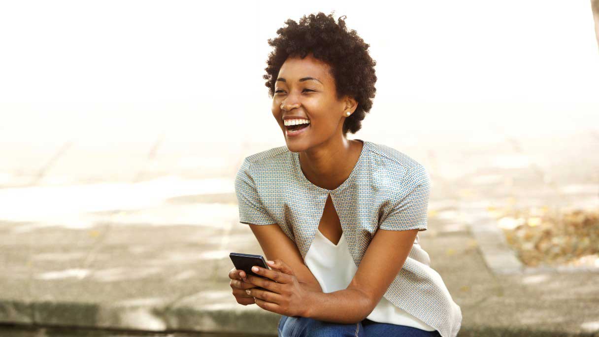 Smiling woman outside on her phone