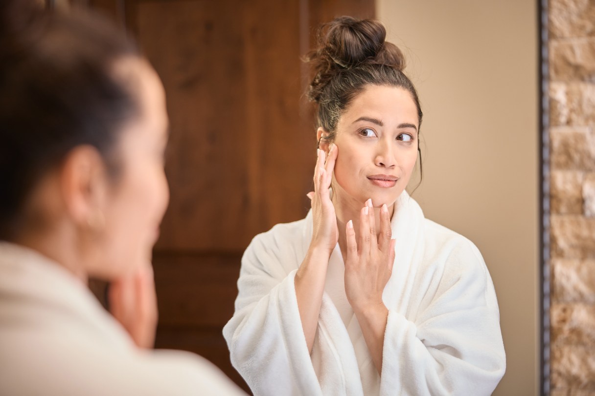 Woman applying serum to her face