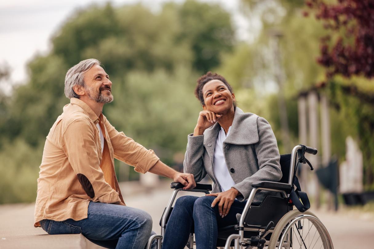Man sitting with woman in a wheelchair