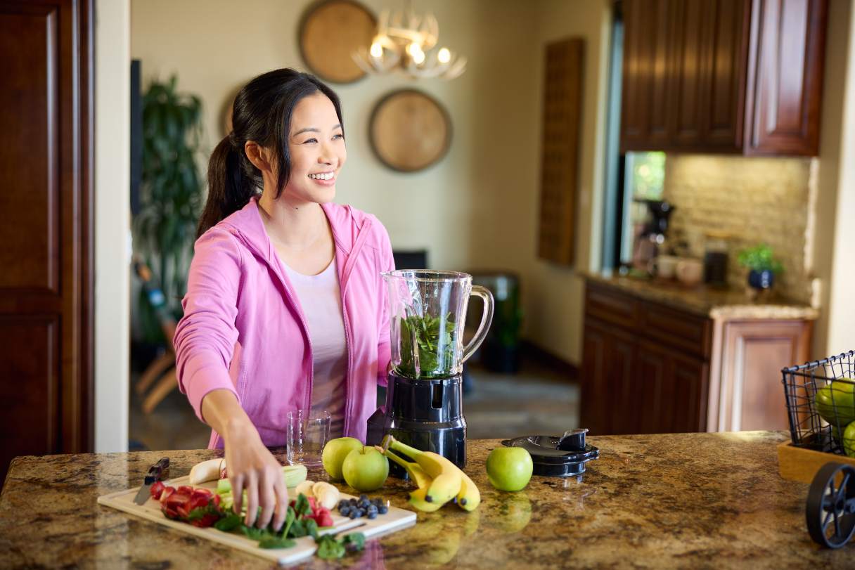 Women preparing a smoothie in a blender