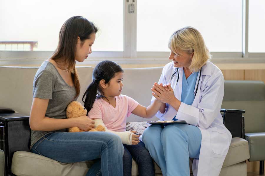 Doctor interacting with woman and young girl