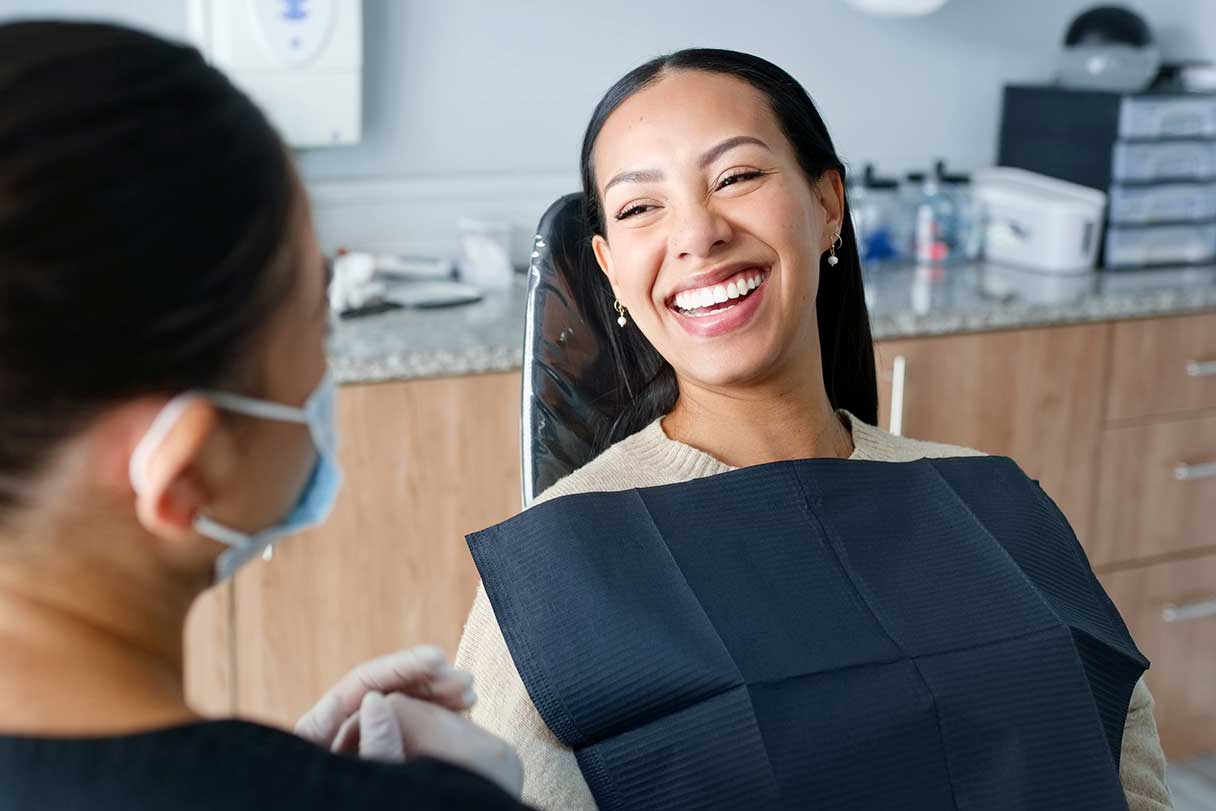 Smiling woman in dental chair smiling at dentist
