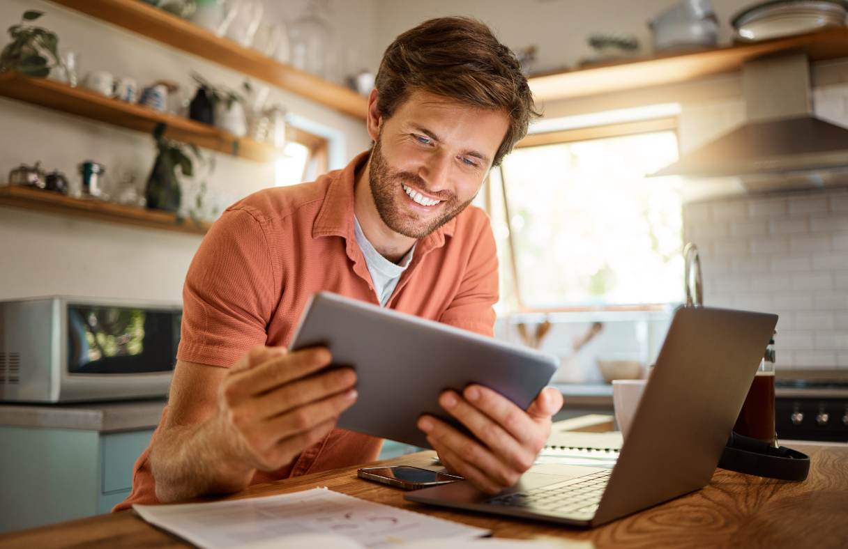 Man smiling at a tablet