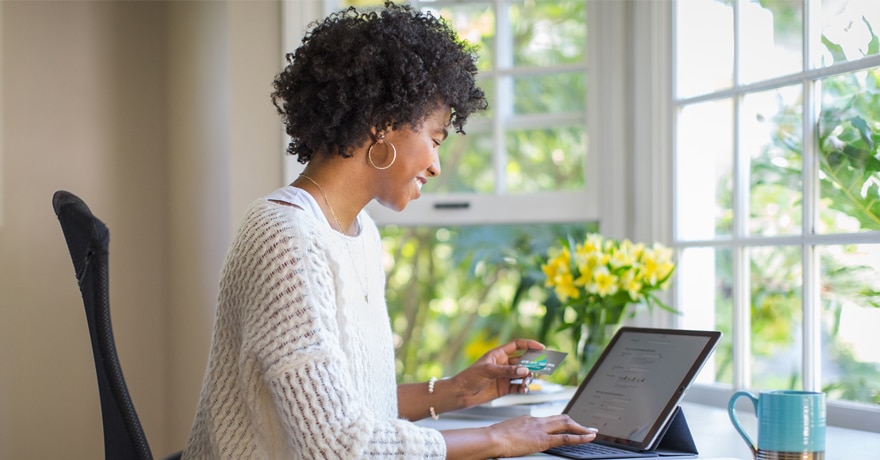 Woman smiling while she works on a tablet in an office