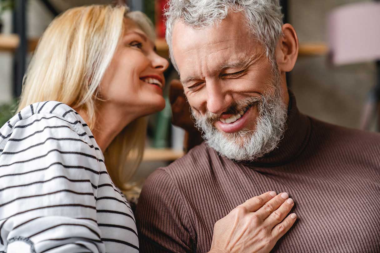 Woman whispering in man's ear