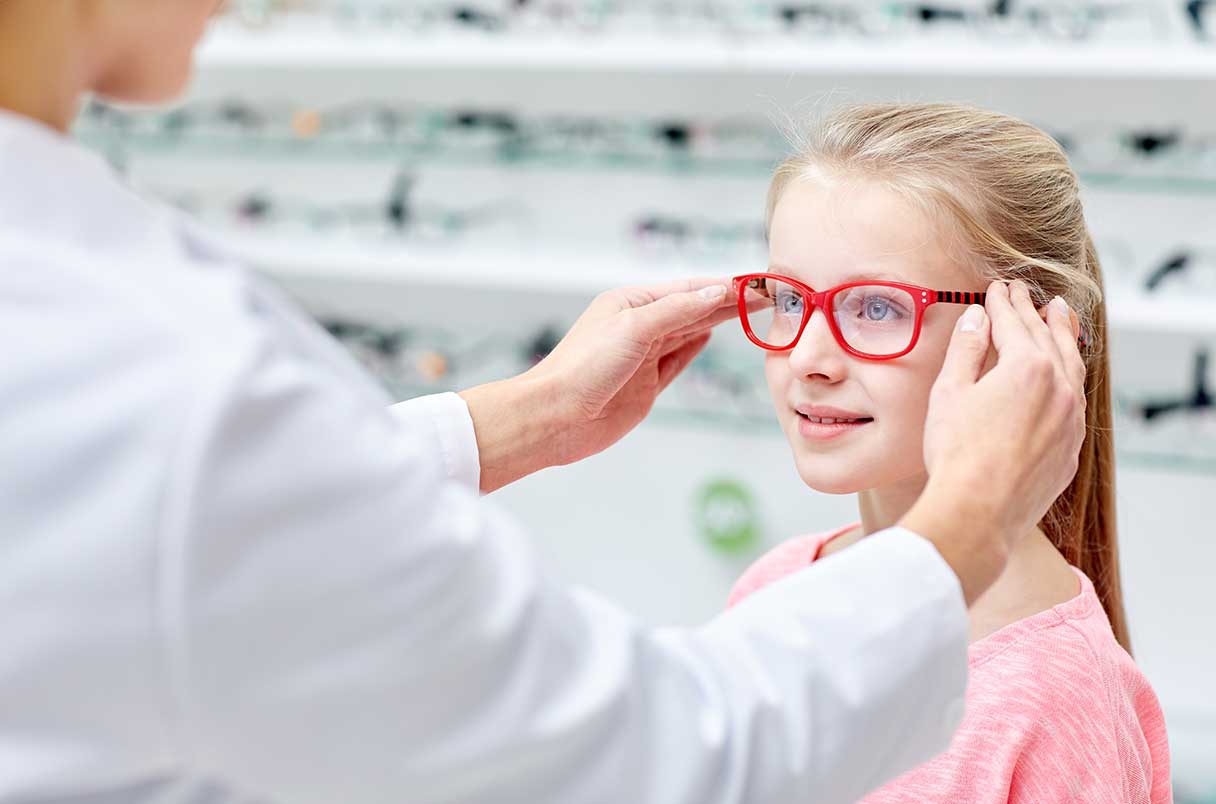 Young girl being fitted with eyeglasses