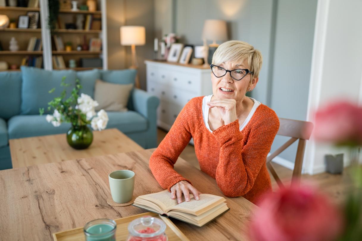 Woman in glasses reading book at a table