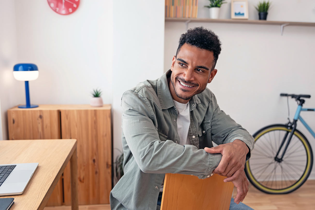 Smiling man leaning against chair