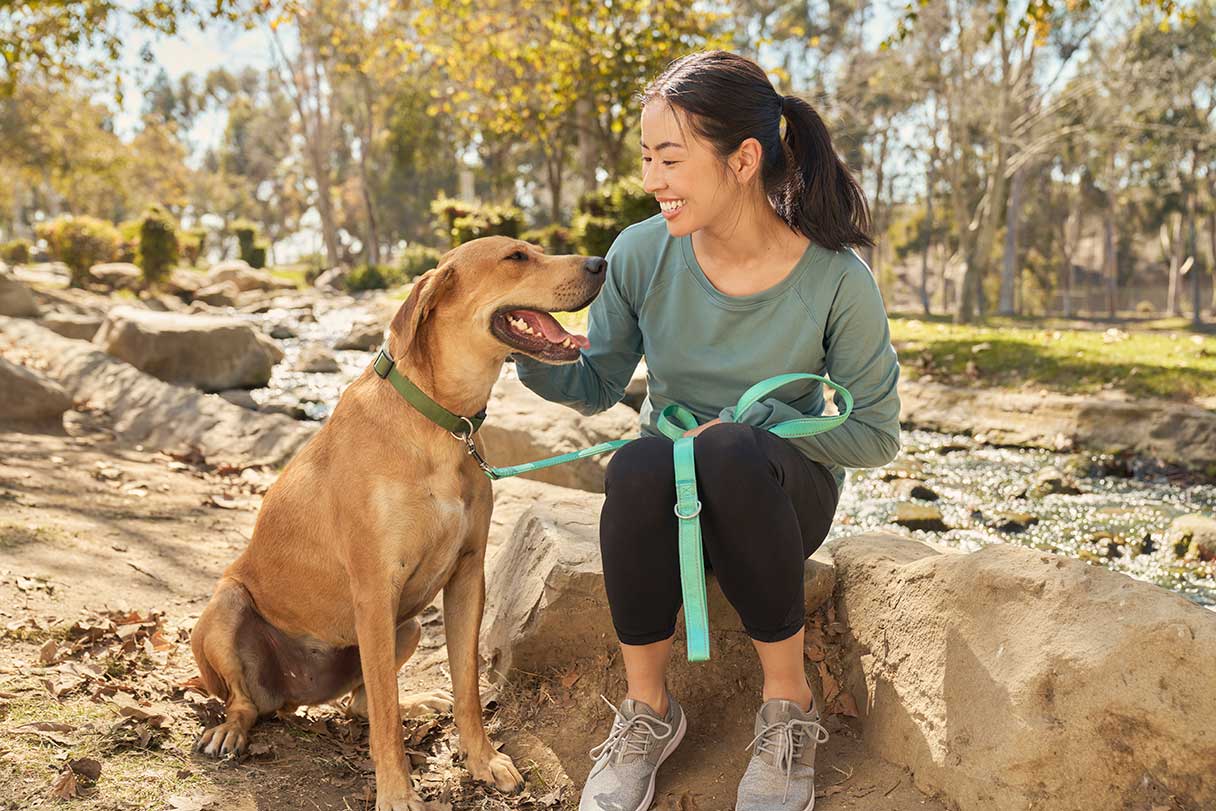 		Woman petting dog outside on hiking trail