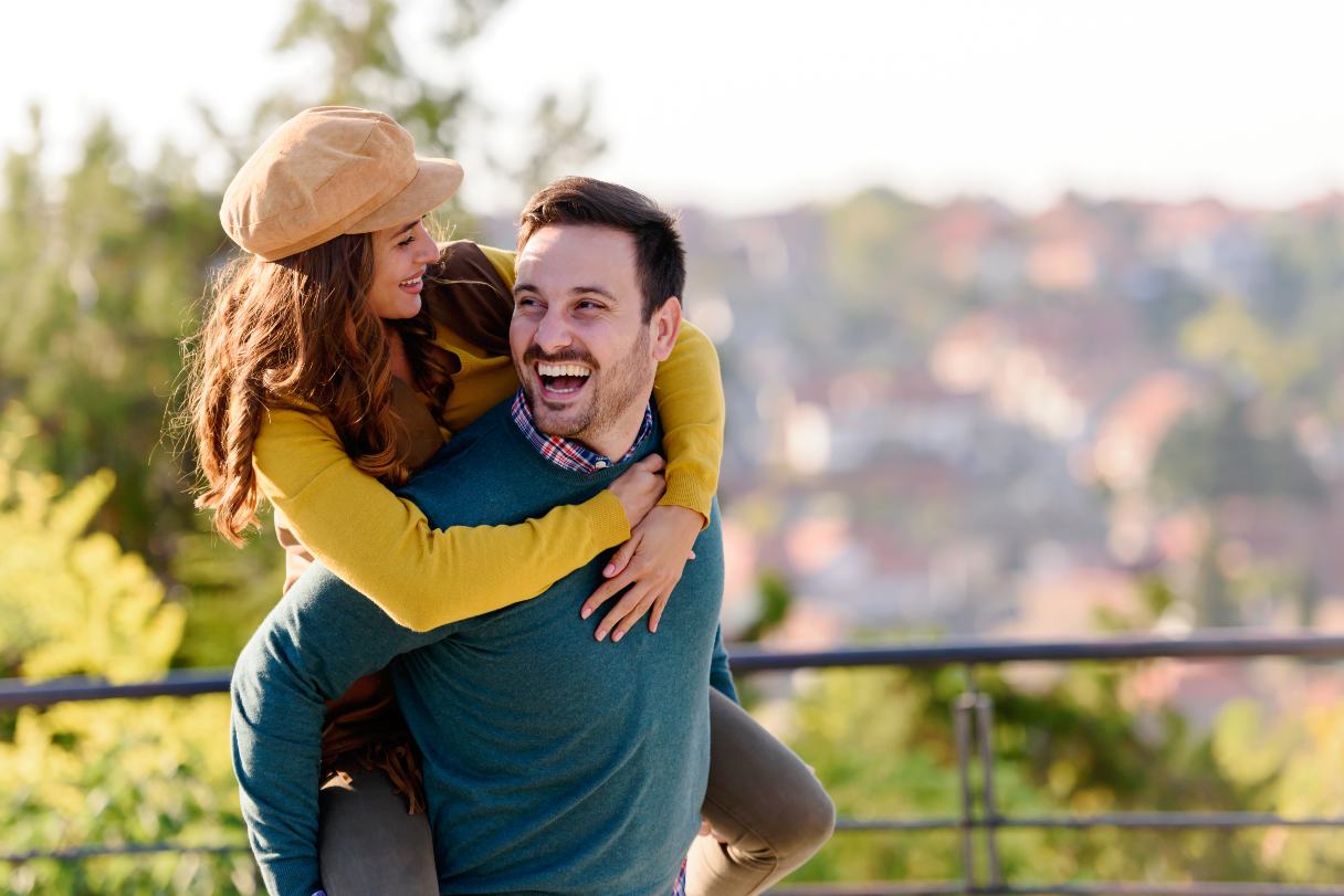 Smiling man, carrying a woman on his back