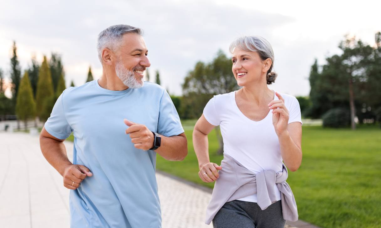 Man and woman smiling at each other as they run together