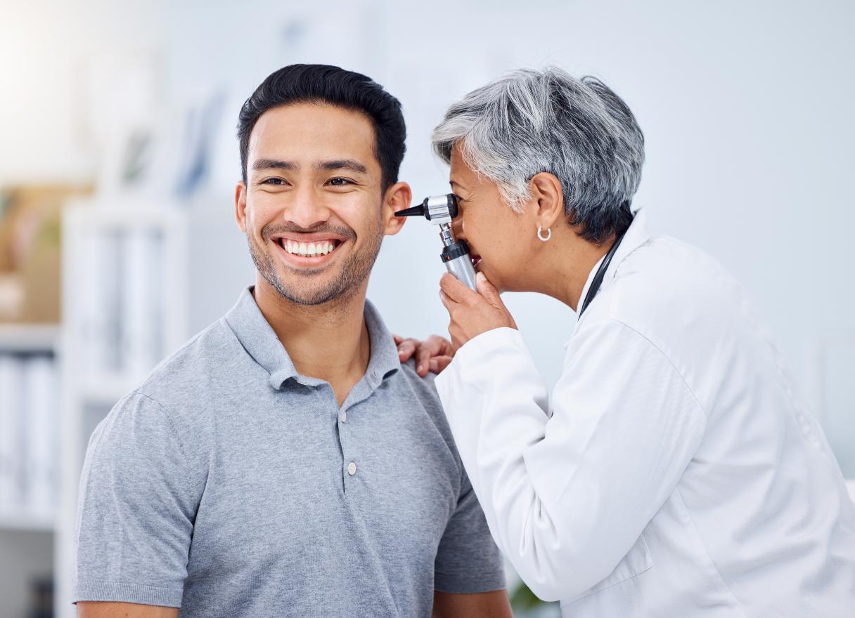 Doctor examining man's ear