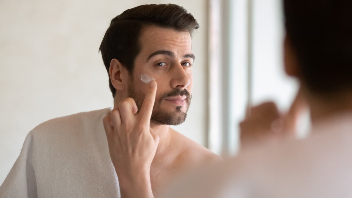 Man applying serum to his face
