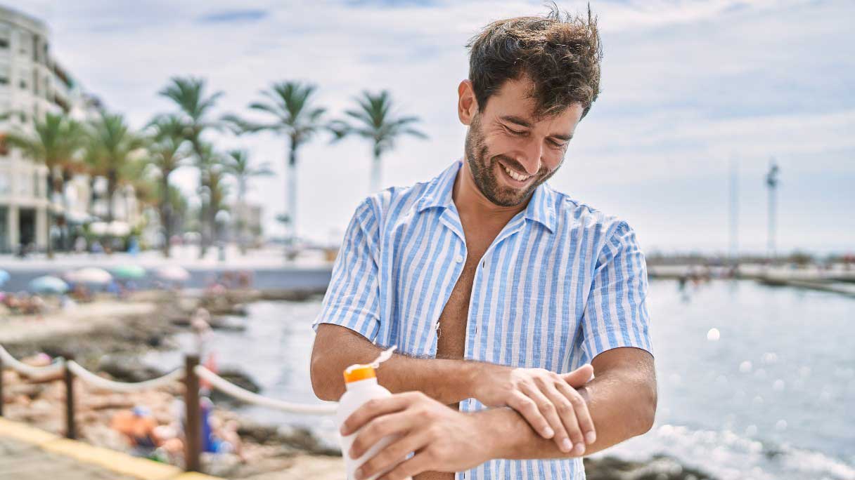 Man applying sunscreen to forearm