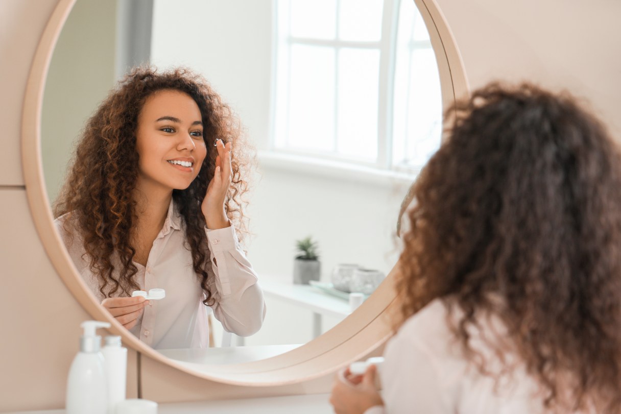 Woman putting in contact lenses