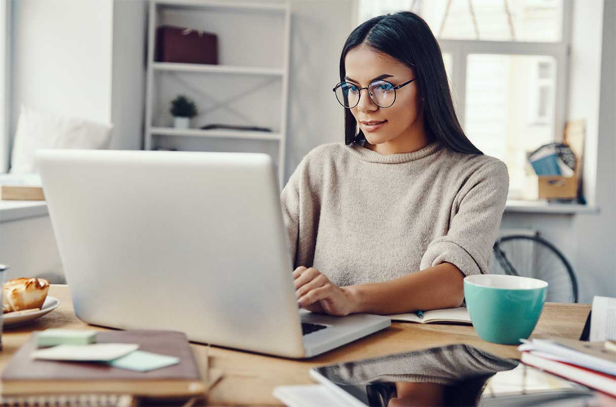 Woman in glasses, working on a laptop