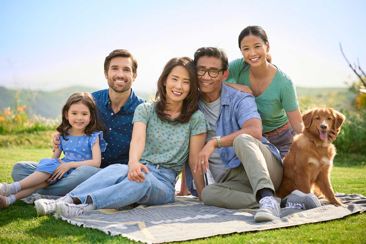 Family sitting on picnic blanket outside