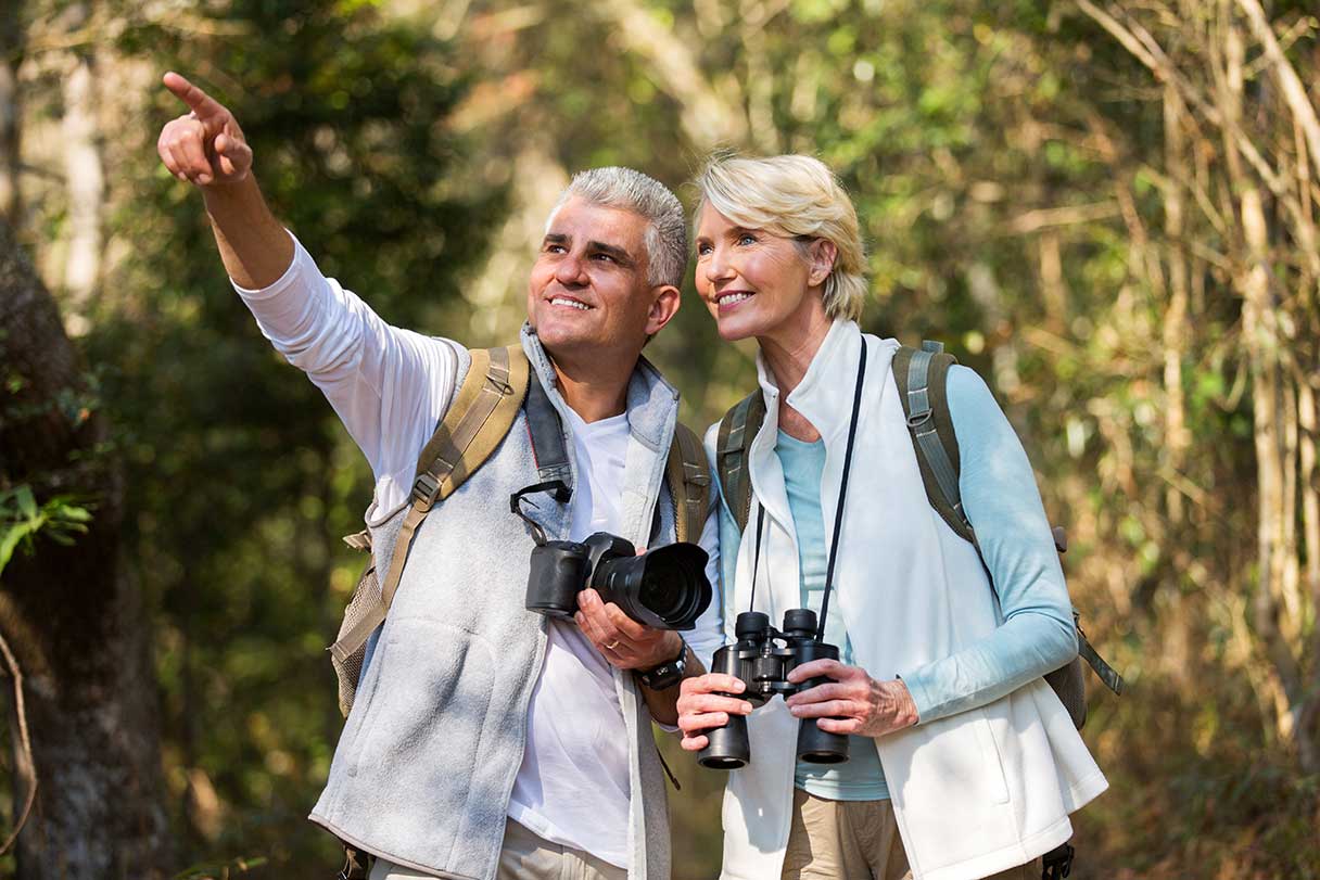 Senior couple with binoculars around their neck