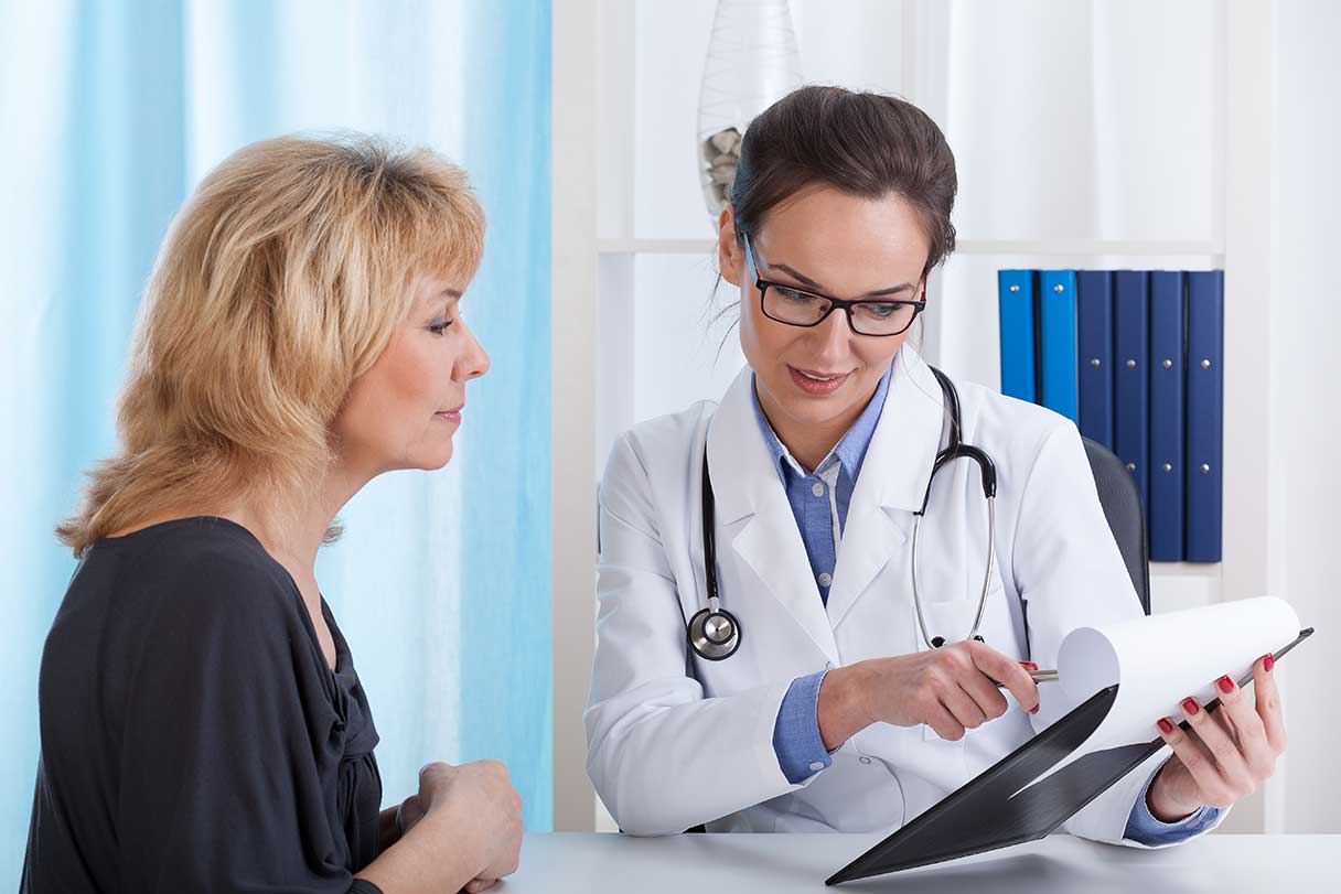 Doctor showing a woman a chart on clipboard