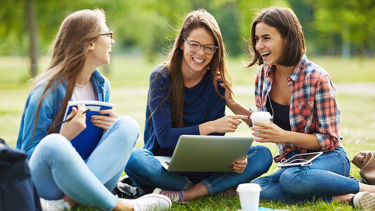 Teenage girls sitting on grass together