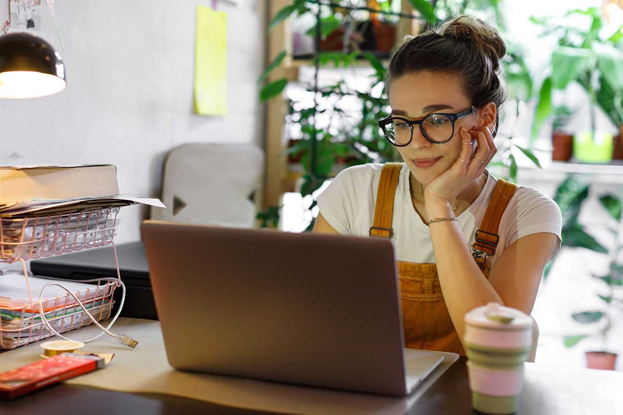 Woman in glasses looking at laptop screen