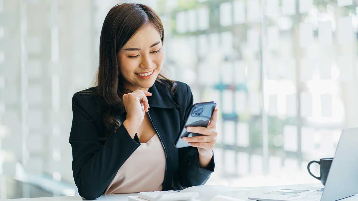 Woman looking at her smartphone, smiling
