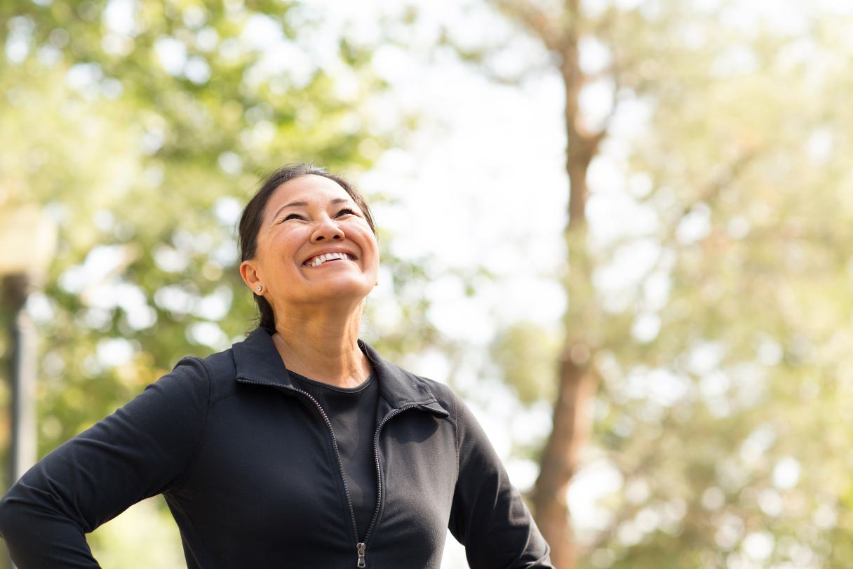 Woman in athleisure outside, smiling