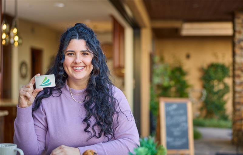 Smiling woman holding CareCredit credit card